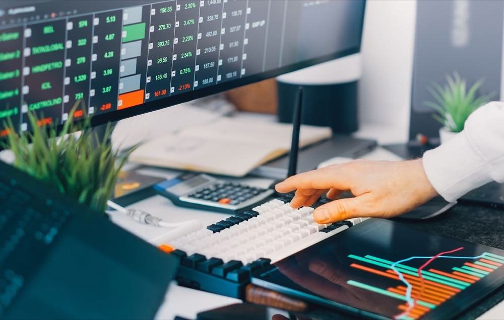 Pantallas con series de datos y una mano sobre el teclado